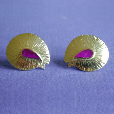 E-4: Sugilite was inlaid into these 18 karat gold earrings. This rare gemstone adds a beautiful accent to these understated earrings. For more information please call: (307) 382-3195
