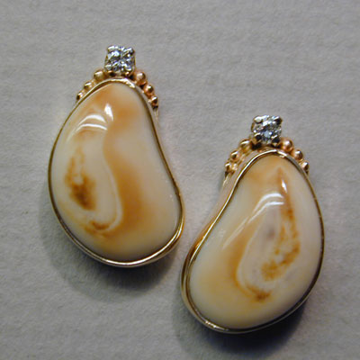 EE-1: Very practical and comfortable, these 18 karat gold earrings can be worn for casual or dressy occasions. The two five point diamonds hi-lite this pair of Rocky Mountain Elk Ivories. ( $650.00 ) For more information please call: (307) 382-3195