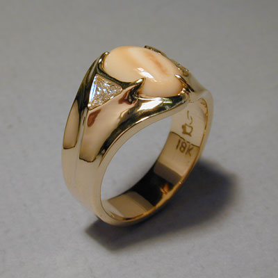 ER-17: The two 1/2 carat triangle shaped diamonds on each side of this elk ivory ring are subtle but certainly add a touch of class to this contemporary design. For more information please call: (307) 382-3195
