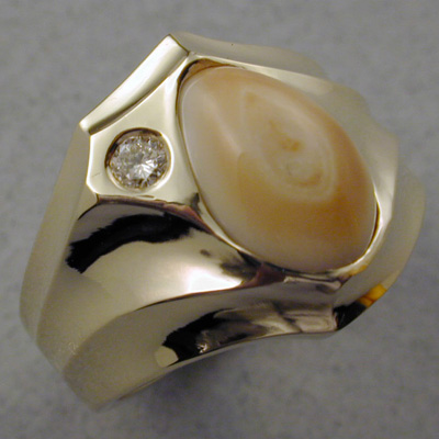 ER-4: Smooth flowing lines make this 18 karat gold ring very striking with a contemporary flair. The subtle color of the Rocky Mountain Elk Ivory stands in contrast to the15 point brilliant cut diamond. A very comfortable and durable design. ( $1,825.00 ) For more information please call: (307) 382-3195