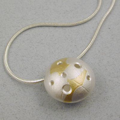 P-10: This sterling silver and 22 karat gold bead is called "Galaxie". Each bead is a bit different because they are each hand made. This bead is also made in 18 karat gold. Each silver and gold bead comes with an 18" snake chain. For more information please call: (307) 382-3195