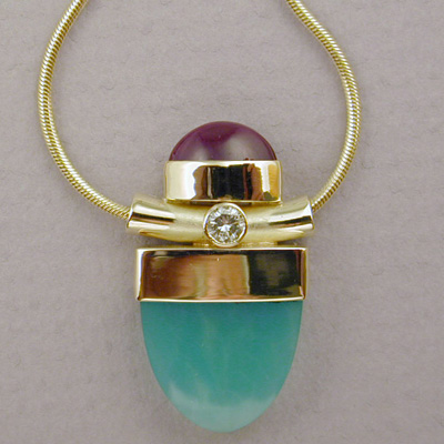 P-4: If you like color and 18 karat gold in your jewelry here you are! The design contains Sugilite (the purple stone) and Chrysoprase (the green one). The intense colors of these gemstones make this pendant an attention getter. For more information please call: (307) 382-3195
