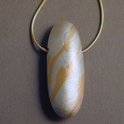 P-5: This sterling silver hollow formed bead has splashes of 20 karat gold fused to it's textured surface. No two beads are alike although similar making each a one of a kind design. The chain is an 18 karat snake chain that is very comfortable and durable. For more information please call: (307) 382-3195