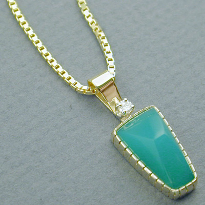 P-6: Australian chrysoprase and a small diamond accent this 18 karat gold, pendant. For more information please call: (307) 382-3195