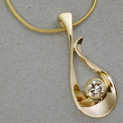 P-7: A one half carat tube set diamond is the centerpiece for this 18 karat gold pendant. For more information please call: (307) 382-3195