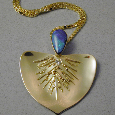 P-9: Australian Opal and a small diamond accent this Aspen Leaf shaped pendant. The texture applied to this 18 karat gold design was achieved by using a technique called "Granulation". For more information please call: (307) 382-3195