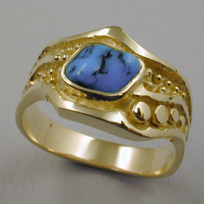 R-8: This 18 karat gold ring is comfortable to wear and will not snag clothing. The design is accented with a cabachon cut piece of gem turquoise from Kingman, Arizona. For more information please call: (307) 382-3195